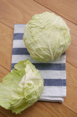 Ahşap masada çizgili bir peçete üzerinde yeşil, taze Kurtarıcı lahanaları.