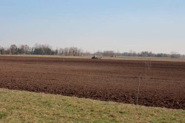 Traktör büyük tarımsal tarlaları erken bahar mevsiminde ekime hazırlıyor.