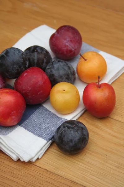 Ganze Gelbe Rote Und Lila Pflaumenfrüchte Auf Einem Holztisch Prunus — Stockfoto