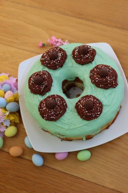 Kolçikolata yuvalı paskalya şifonlu kek. Ahşap masadaki yeşil jöleli.