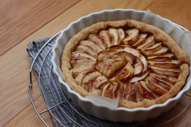 Geleneksel Fransız pastası, ahşap bir masada dilimlenmiş elmalı tart.