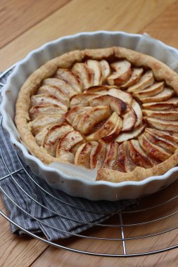 Geleneksel Fransız pastası, ahşap bir masada dilimlenmiş elmalı tart.