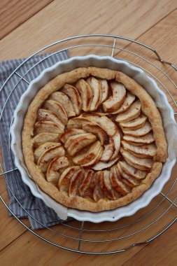 Geleneksel Fransız pastası, ahşap bir masada dilimlenmiş elmalı tart.
