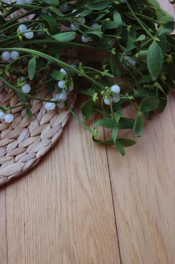 Tahta masada üzerinde beyaz böğürtlen bulunan bir sürü Misteletoe dalı. Viscum albümü 