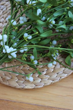 Tahta masada üzerinde beyaz böğürtlen bulunan bir sürü Misteletoe dalı. Viscum albümü 