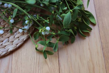 Tahta masada üzerinde beyaz böğürtlen bulunan bir sürü Misteletoe dalı. Viscum albümü 