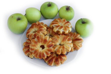 Tarçınlı ev yapımı puf elma halkaları ve beyaz arkaplanda beyaz seramik tabakta kamış şekeri ve taze elmalar.