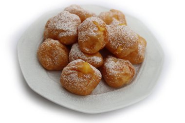 Beyaz arka planda izole edilmiş bir tabakta karnaval için Frittelle adında kremayla dolu geleneksel İtalyan börekleri.