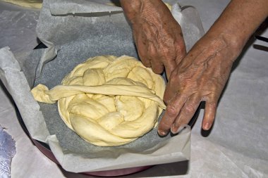 Kutlama pastası yoğuran yaşlı bir ev kadınının elleri. Yaklaşan kutlamalar için ekmek. Ekmek daha sonra fırında pişirilir..