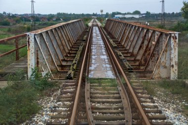 Tren metal bir köprüye çarpar. Rayların ve köprünün manzarası.