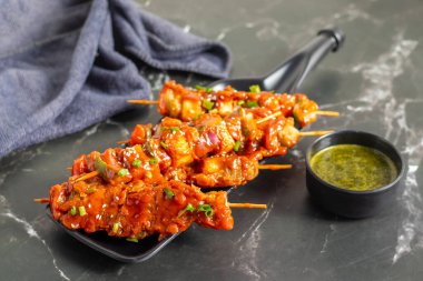 Paneer Satay, terbiye edilmiş paneer küpleriyle yapılmış baharatlı fıstık veya yoğurt sosuyla servis edilen ızgara Hint aperatifi..