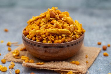 Bombay karışımı baharatlı, çıtır çıtır bir Hint aperatifi. Kızarmış mercimek, fındık, nohut unu, erişte ve aromalı baharat karışımı..