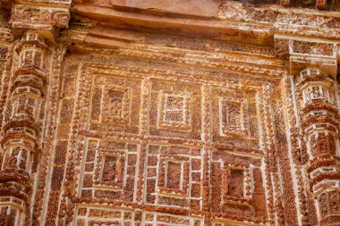 Shyamray Tapınağı 'ndaki karmaşık terasotta panelinde dans eden figürler, müzisyenler, hayvanlar ve çiçekli motiflerle dolu eşmerkezli kemerler tasvir ediliyor..