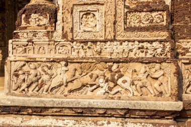 Radhaamadan Gopal Temple 'daki ayrıntılı terracotta panelleri müzisyenleri, fanatikleri, hayvanları ve günlük hayat sahnelerini resmediyor, incelikli Malla dönemi sanatçılık, adanmışlık ve hikaye anlatımlarını gözler önüne seriyor..