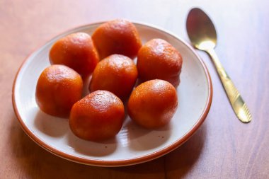 Gulab Jamun yumuşak, bol yağda kızartılmış, kokulu şeker şurubuna batırılmış zengin, sulu ve geleneksel olarak sıcak servis edilen bir Hint tatlısıdır..