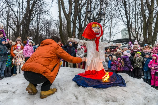 Maslenitsa (settimana di frittella). L'uomo dà fuoco ad un'effigie dell'inverno . — Foto Stock