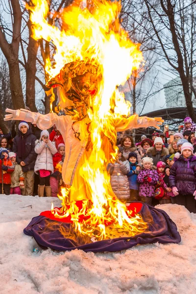 Maslenitsa (semana de tortitas). Quemando la efigie del invierno, rodeado de gente . — Foto de Stock