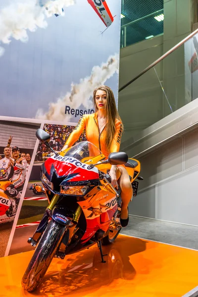 Motopark-2015 (BikePark-2015). Menina bonita em bicicleta esportiva perto do estande com óleos . — Fotografia de Stock