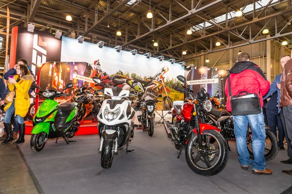 Motopark-2015 (BikePark-2015). La gente está mirando al stand con motocicletas y scooters . — Foto de Stock