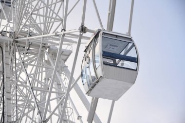 Dönme dolap çekimi, dönme dolap, kışın gökyüzüne karşı. Beyaz dönme dolabın modern kabini.