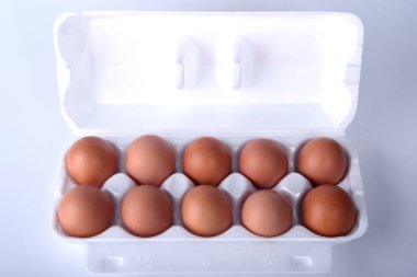 Beyaz arka planda beyaz ambalajlı tavuk yumurtası.