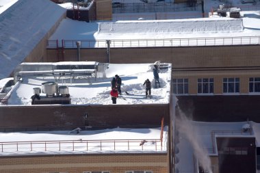 15 Şubat 2021 'de Moskova' da kış mevsiminde binanın çatısından kar temizlendi.