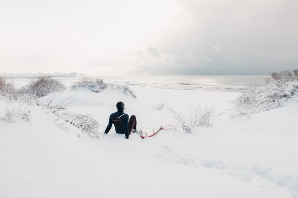 겨울과 파도타기를 사람들은 눈덮인 해변에 파도타기 파도를 잠수복을 파도타기를 겨울철 — 스톡 사진