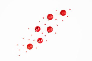 Kırmızı topların dekorasyonu ve beyaz arka planda bulanık konfetiden oluşan Noel kış konsepti. Düz yatış, üst görünüm