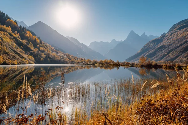 Mountain lake with reflection in the autumn and peak of mountains