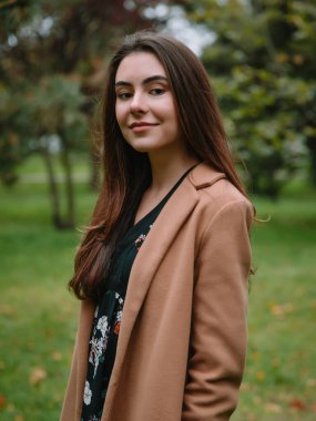 Parktaki genç ve çekici kadının portresi. Ceketli kadın.