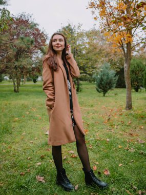 Parktaki genç ve çekici kadının portresi. Ceketli kadın.