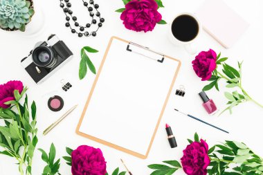 Panosu, günlüğü, film kamerası, şakayıkları, kahve fincanı ve beyaz aksesuarları olan bir kadın çalışma alanı. Düz yatış, üst görünüm.