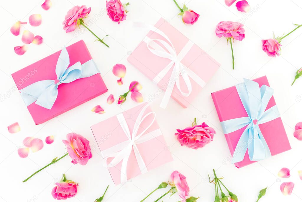 Floral composition of pink roses flowers and gifts on white background. Flat lay, Top view