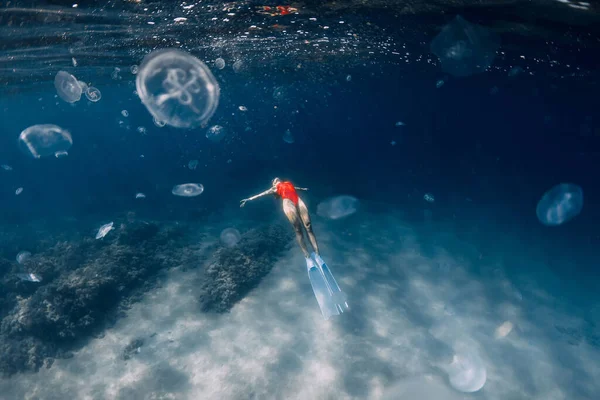 白いフィンとクラゲを水中に持つ女性のフリーダイバー 青い海でクラゲとフリーダイビング — ストック写真