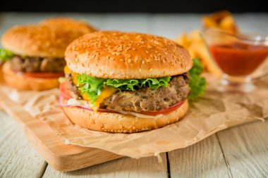 Tahtada biftek ve domates soslu taze Amerikan hamburgeri.