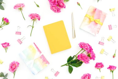 Beyaz arka planda defter, kalem, hediye ve gül çiçekli kompozisyon. Düz yatıyordu. Üst görünüm