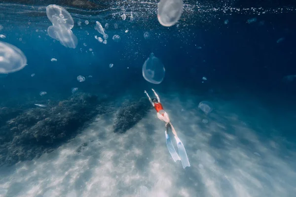 女性のフリーダイバーは青い海でクラゲと一緒に泳ぐ 青い海のクラゲ — ストック写真