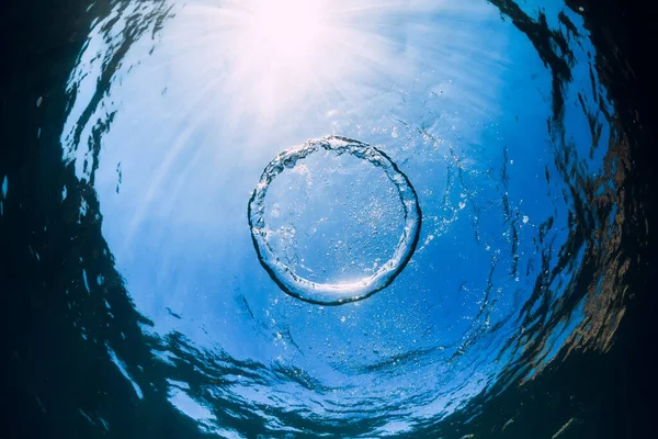 Ring bubble underwater and sun light in transparent ocean. Water texture.