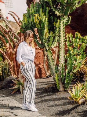 Lanzarote Adası, Kanarya Adaları 'ndaki Kaktüs bahçesinde kaktüslü genç bir kadın.