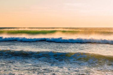 Sıcak gün batımında ya da gün doğumunda okyanus dalgaları. Akşam ışığında dalgalar ve rüzgar
