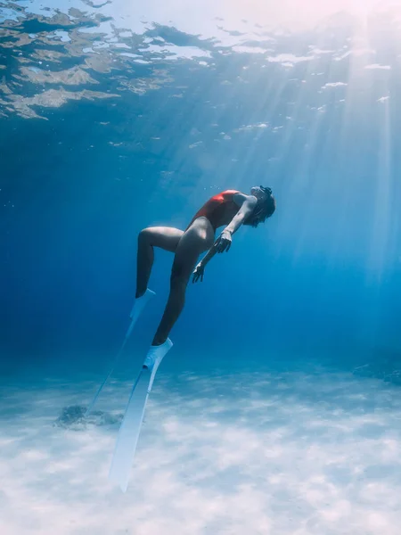 熱帯の海で砂の上に水中でポーズ白いフィンと赤い水着の女性のフリーダイバー スポーティ女の子潜水水中 — ストック写真