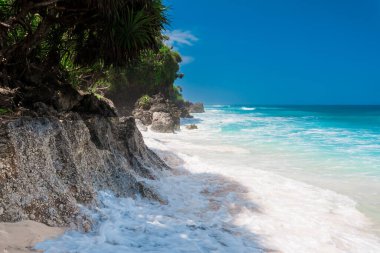 Bali 'de tropik bir sahil. Cennet kumsalı ve dalgalı mavi okyanus