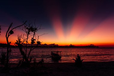 Gili adasında okyanus olan tropikal sahilde gün batımı veya gün doğumu