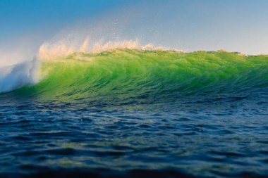 Okyanustaki mükemmel yeşil dalga. Akşam güneşiyle dalgalar kırılıyor