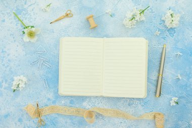 Çiçeklerin yaz kompozisyonu günlük, püskül, makas ve mavi üzerine kalem. Düz yatış, üst görünüm