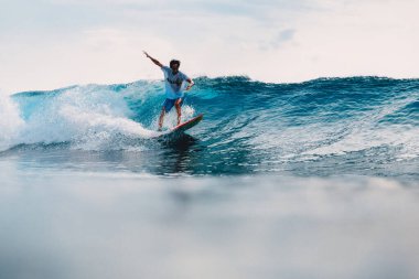11 Mart 2021. Bali, Endonezya. Endonezyalı profesyonel sörfçü Alik Rudiarta okyanus dalgasında sörf tahtasında.