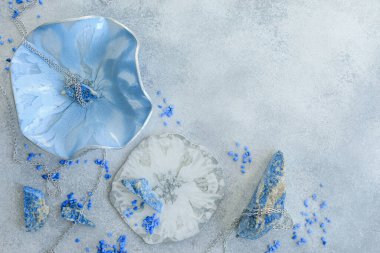 Reçine sanat plakalı kompozisyon ve gri arka planda mavi taşlar. Epoksi reçine sanatı. Düz yatıyordu