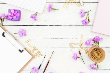 Panosu, defteri, çiçekleri ve aksesuarları olan çalışma alanı. Kadın blog çalışma alanı. Düz yatış, üst görünüm.