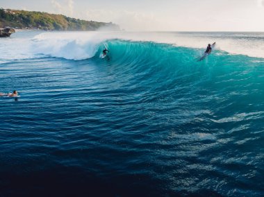İdeal fıçı dalgasında sörf yapan hava manzarası. Mavi mükemmel dalgalar ve okyanustaki sörfçüler