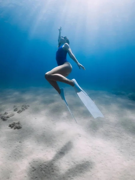 フィンを持つ女性のフリーダイバーは 太陽の光と海の中で水中でポーズやグライド 暖かい水の中でフリーダイビング — ストック写真